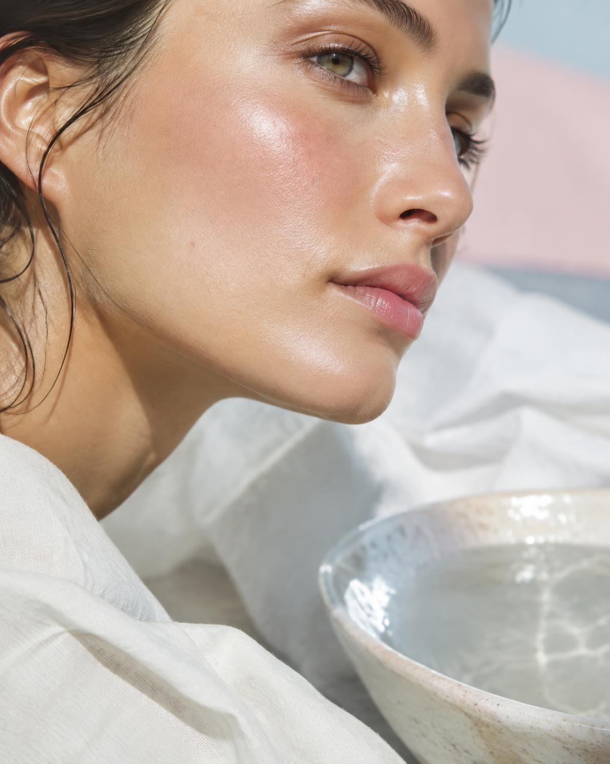 Close-up of glowing, dewy skin in soft sunlight